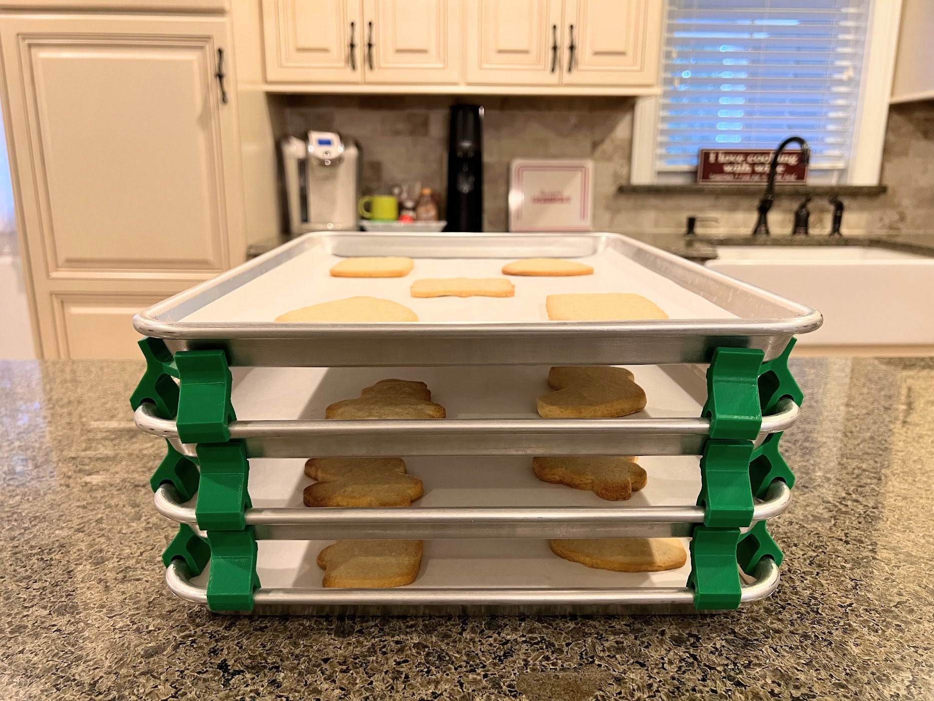 3D printed baking sheet organizers from the front in green, neatly holding and organizing multiple cookie sheets to save counter space in the kitchen.