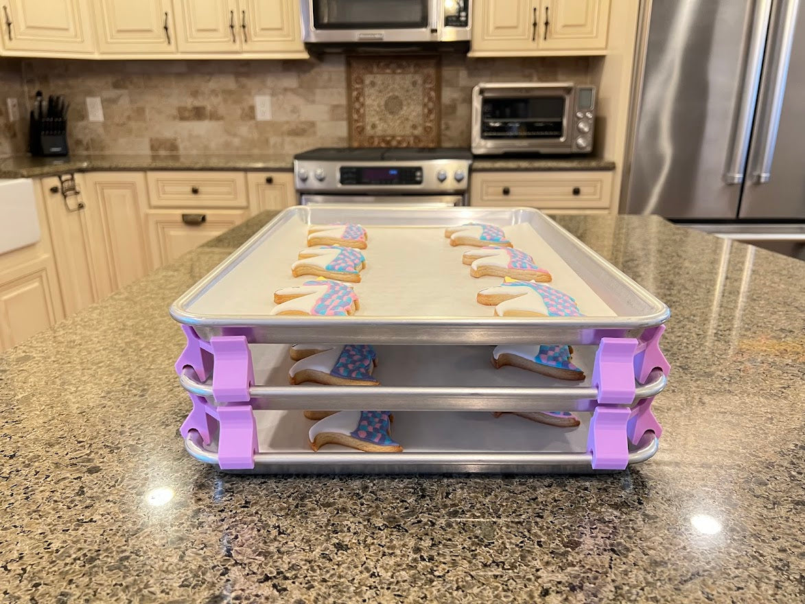 3D printed baking sheet organizers from the front in lavender, neatly holding and organizing multiple cookie sheets to save counter space in the kitchen.