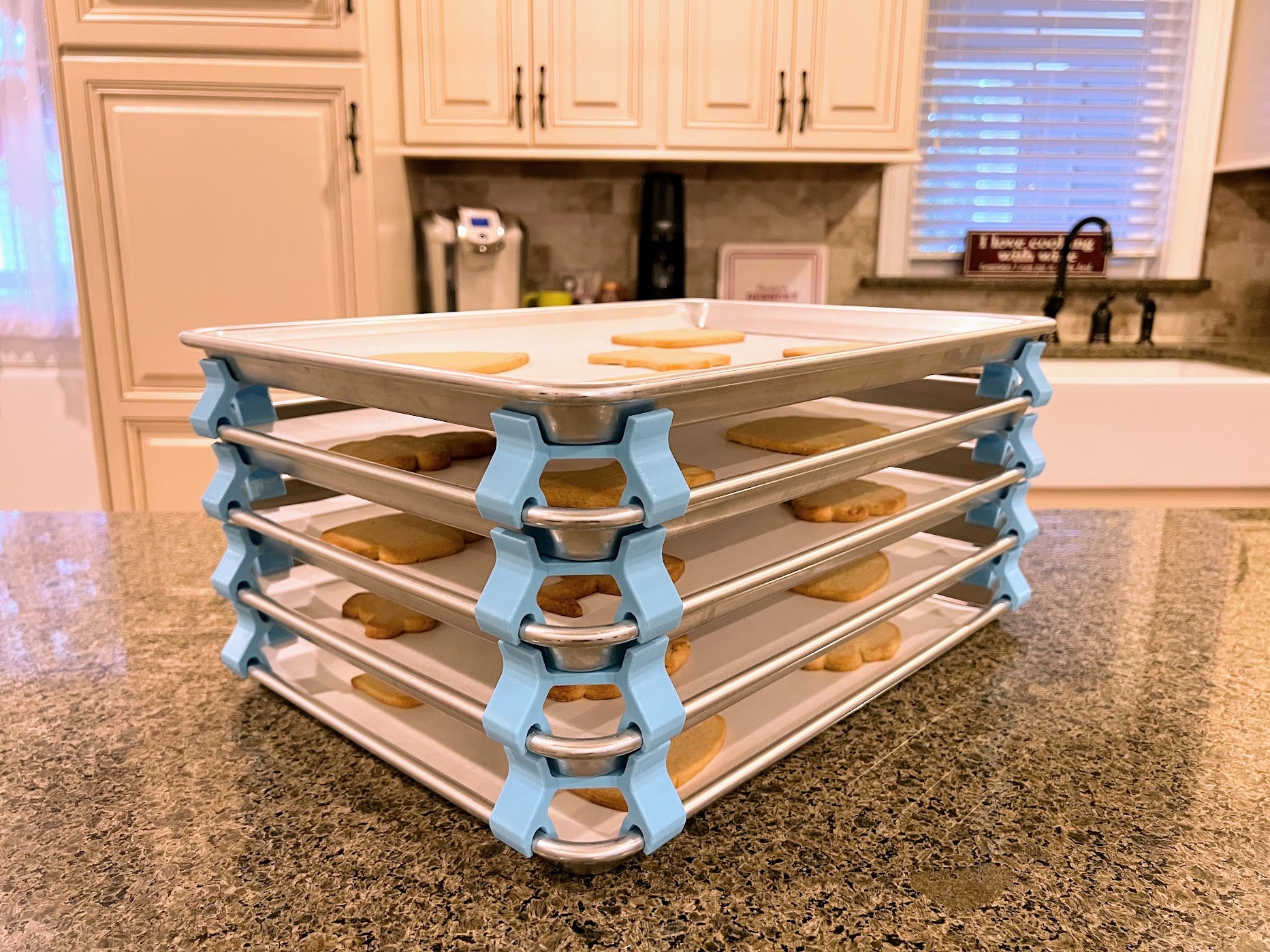 3D printed baking sheet organizers at an angle in light blue, neatly holding and organizing multiple cookie sheets to save counter space in the kitchen.