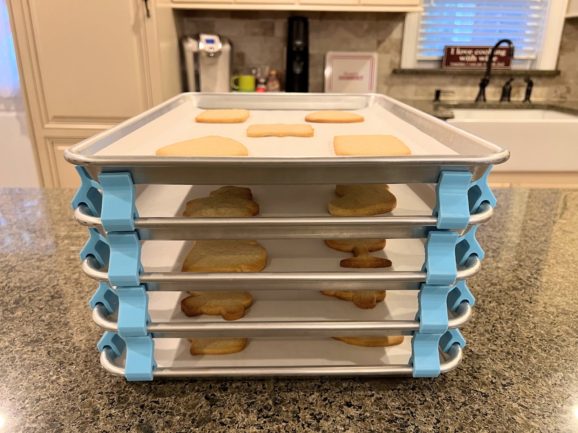3D printed baking sheet organizers from the front in light blue, neatly holding and organizing multiple cookie sheets to save counter space in the kitchen.