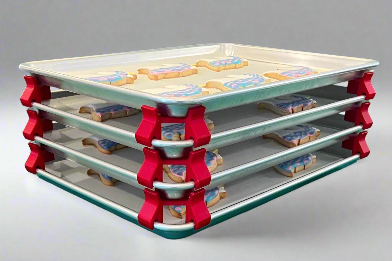 3D printed baking sheet organizers at an angle in red, neatly holding and organizing multiple cookie sheets to save counter space in the kitchen.