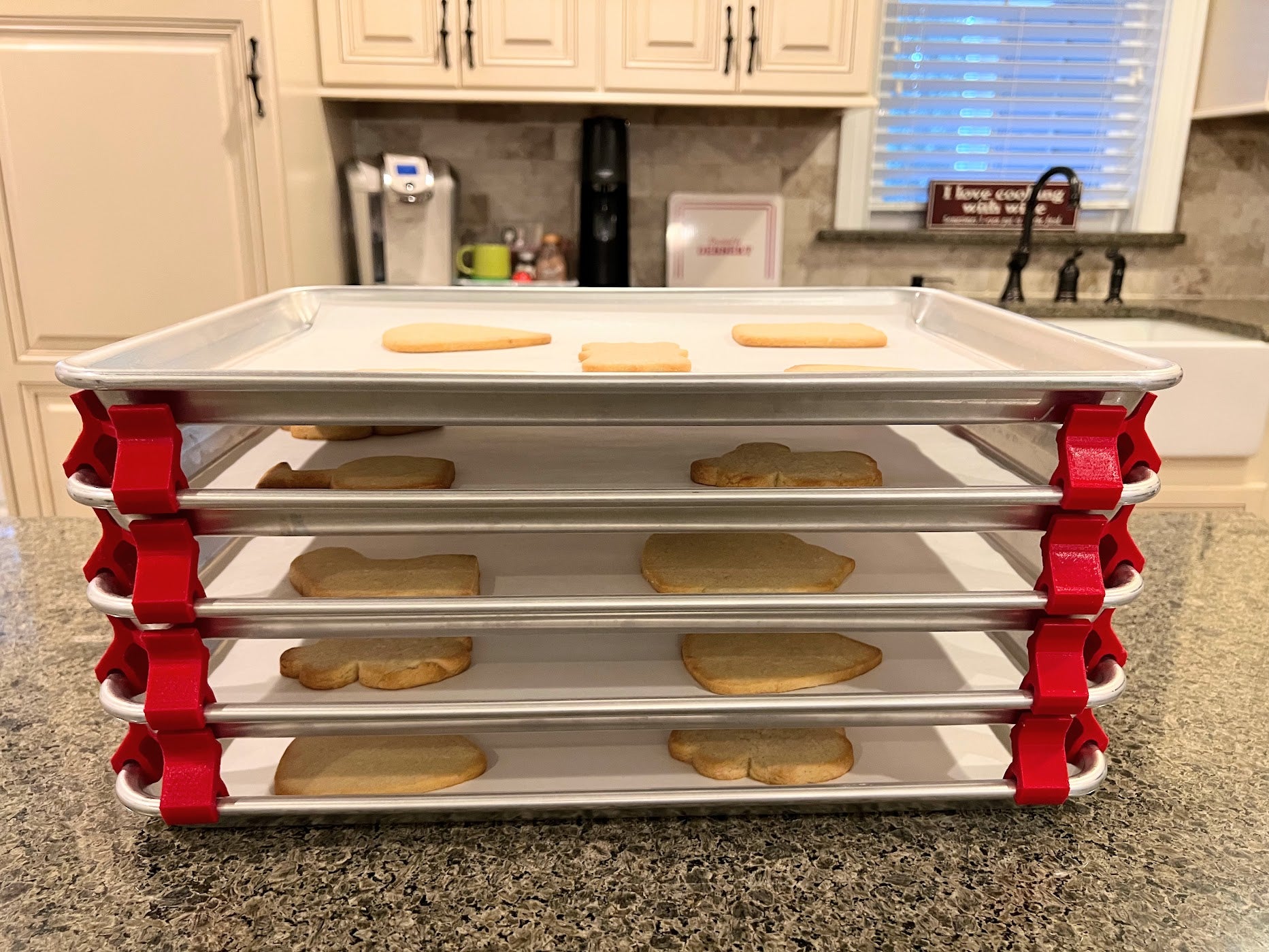 3D printed baking sheet organizers from the side in red, neatly holding and organizing multiple cookie sheets to save counter space in the kitchen.