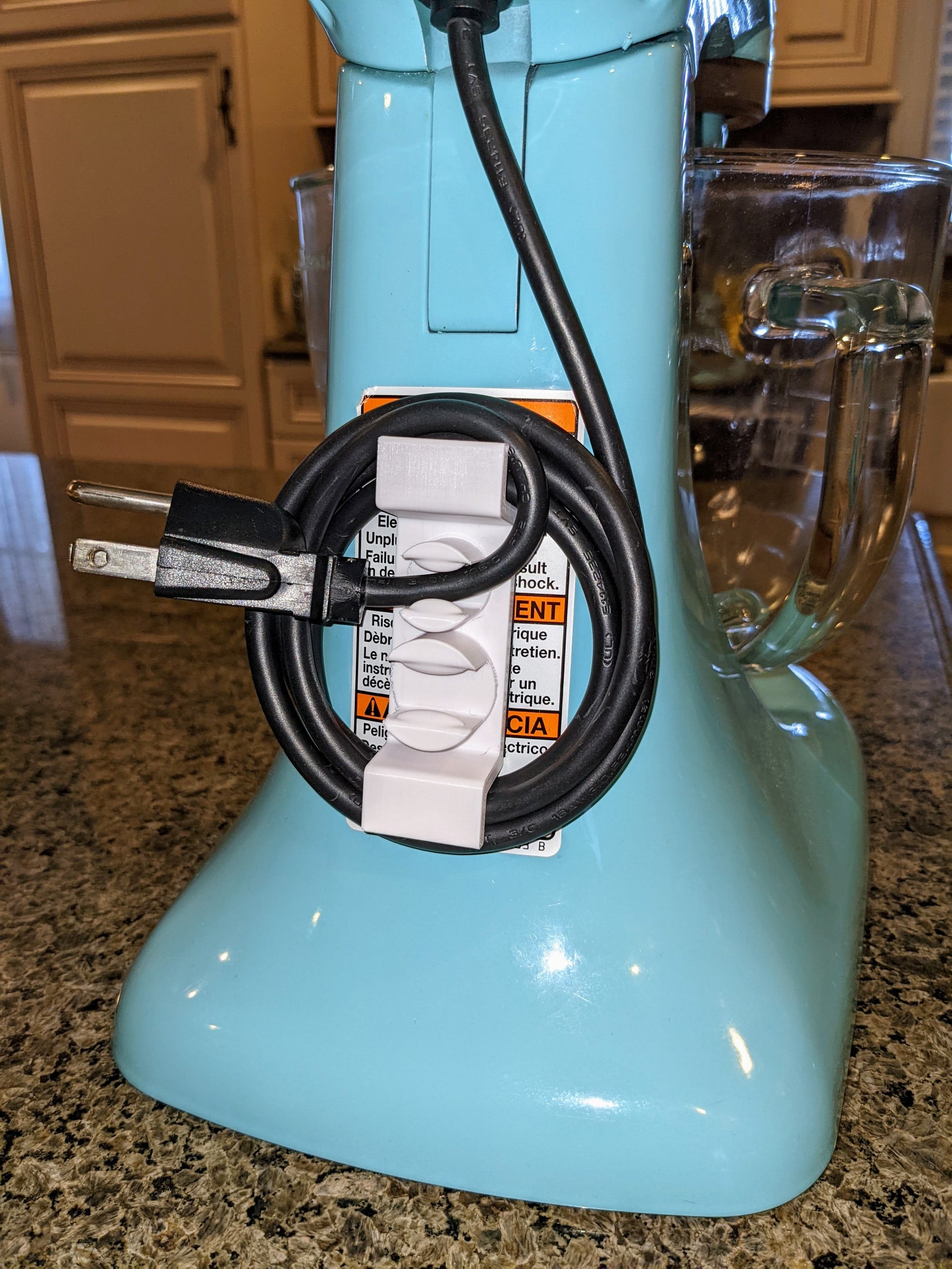 White appliance cord wrap on a light blue mixer.
