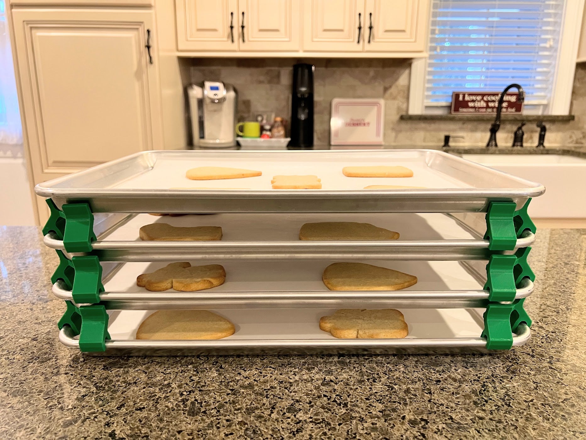 3D printed baking sheet organizers from the side in green, neatly holding and organizing multiple cookie sheets to save counter space in the kitchen.