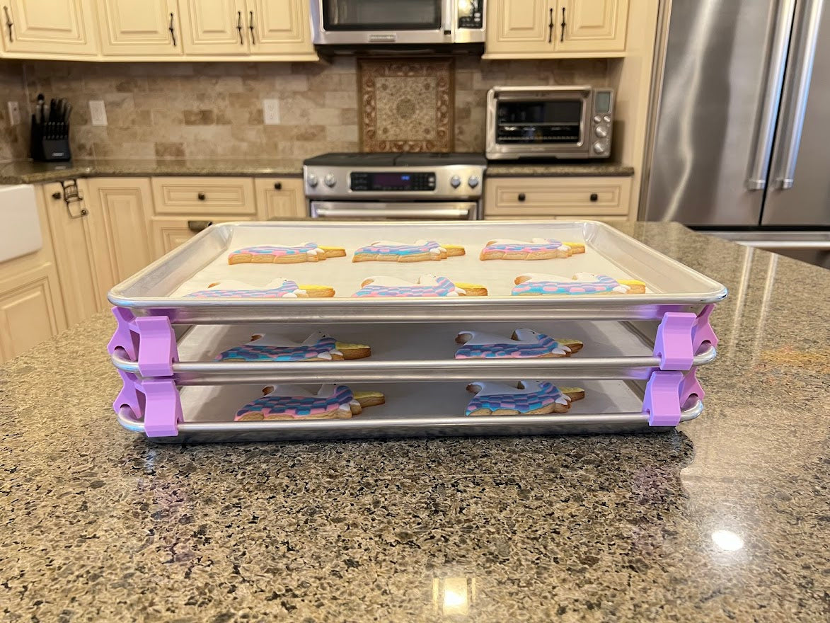 3D printed baking sheet organizers from the side in lavender, neatly holding and organizing multiple cookie sheets to save counter space in the kitchen.