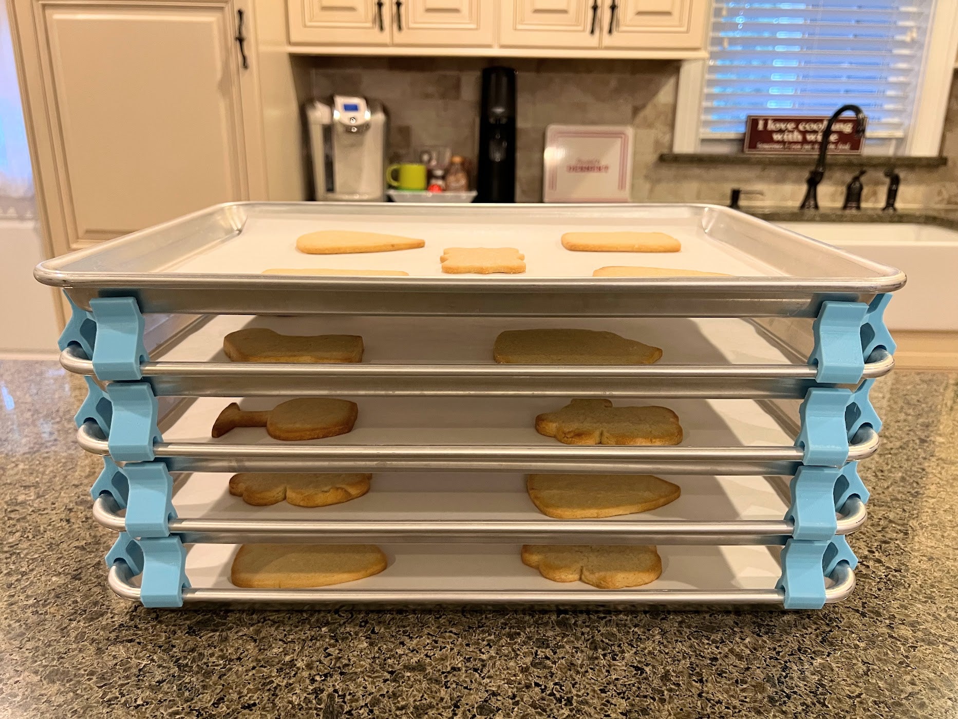 3D printed baking sheet organizers from the side in light blue, neatly holding and organizing multiple cookie sheets to save counter space in the kitchen.