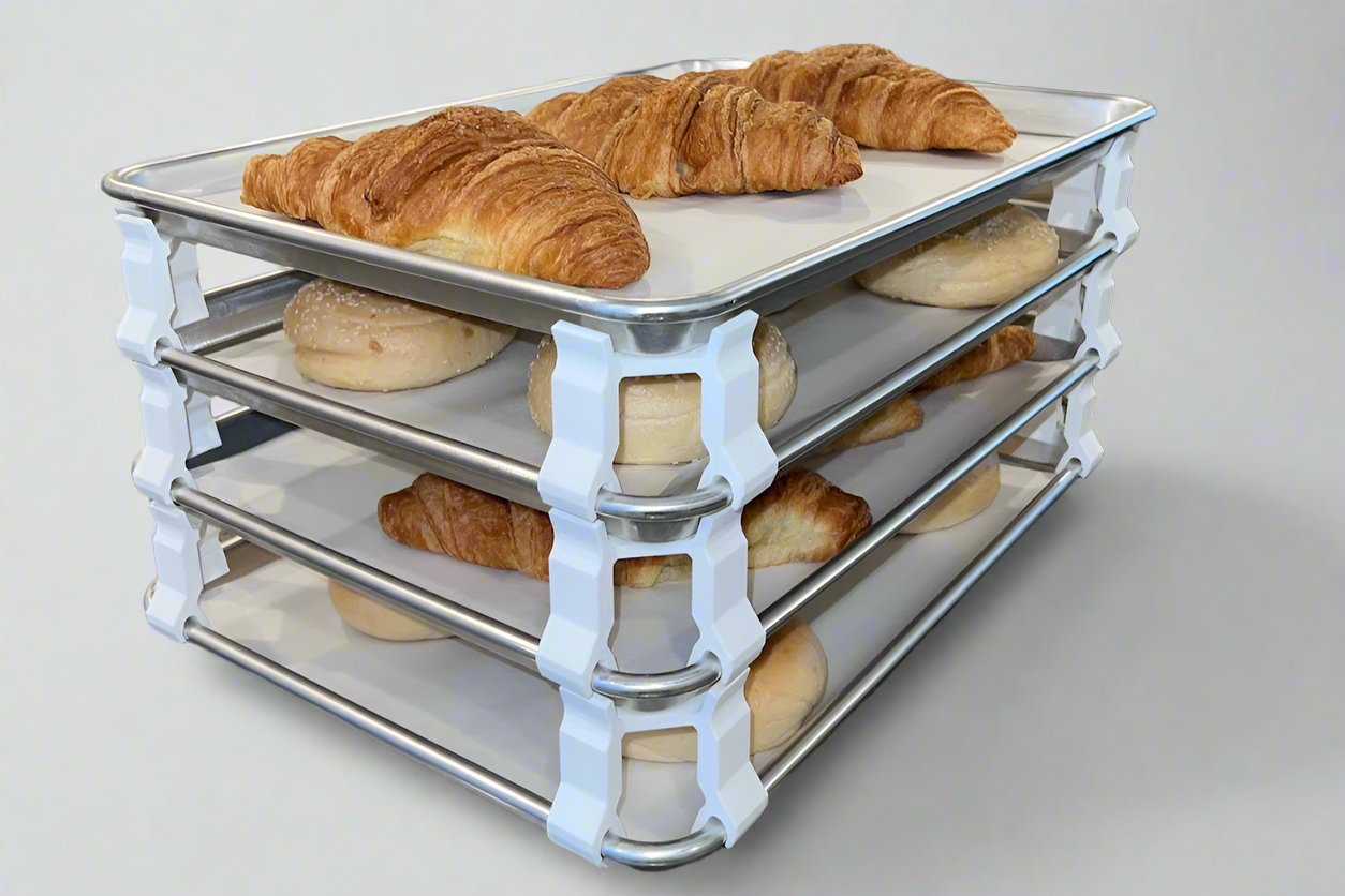 3D printed baking sheet organizers at an angle in white, neatly holding and organizing multiple cookie sheets to save counter space in the kitchen.