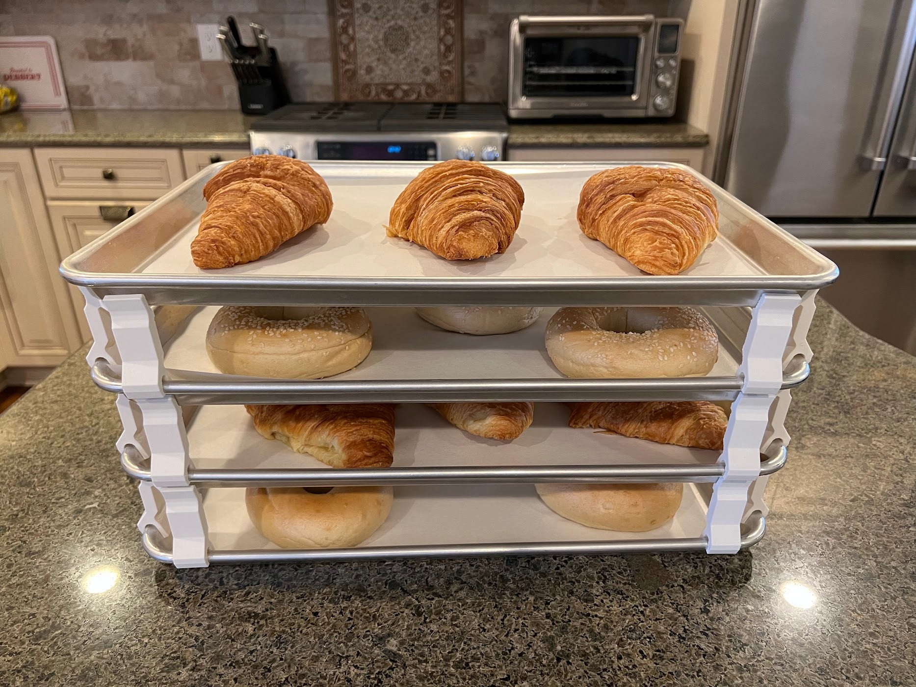 3D printed baking sheet organizers from the side in white, neatly holding and organizing multiple cookie sheets to save counter space in the kitchen.